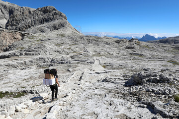 sherpa carrying supplies with a backpack in the middle of the mountains