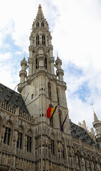 Fototapeta premium Brussels town hall and the belgian flag in Grand Place
