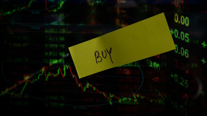 Concept of Buy written on sticky notes attached on share market graph.