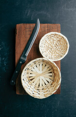 Empty kitchen background with old cutting board, knife and empty baskets for your product. food background.Top view.