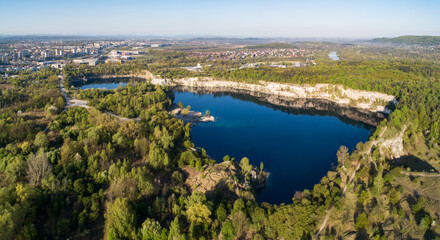 Fototapeta na wymiar Krakow, Poland. Zakrzowek lake with steep cliffs in place of former flooded limestone quarry in Twardowski Rocks. Popular recreational place. Aerial panorama at sunrise