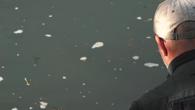 A fisherman catches fish in the river with spinning. Fishermen on the river bank. Salmon fishing in the river