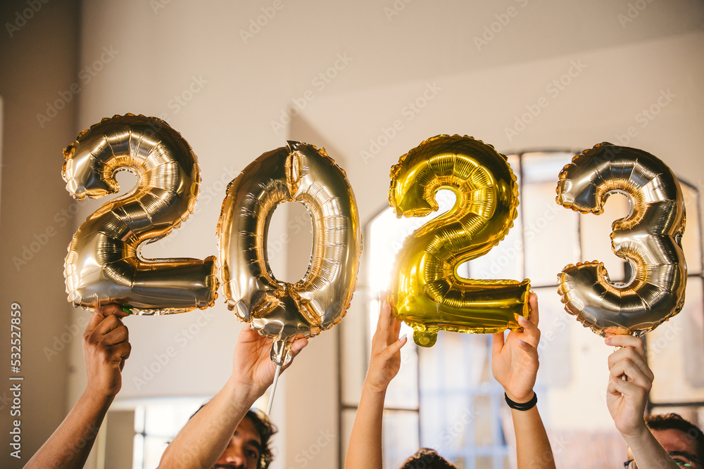 Wall mural Group of friends at a party celebrate happy new 2023 year with elegant inflatable gold text - People have fun together at home