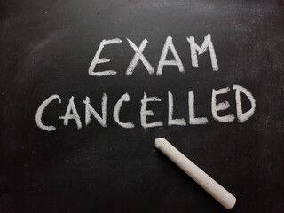 Exam cancelled written on blackboard or slate with chalk.