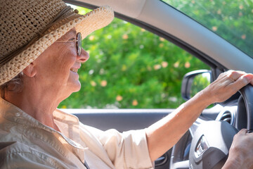 Senior woman driving car smiling