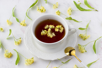 Healing lime tea in a white cup on a white background. Healthy tea