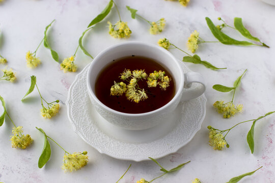 Healing lime tea in a white cup on a white background. Healthy tea