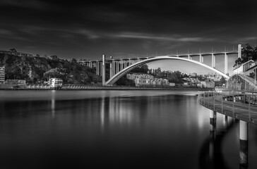 Douro river. Arrabida bridge. View of Porto / Vila Nova de Gaia from Afurada, Portugal. Long exposure in black and white.
