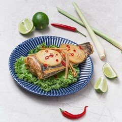 Grilled Catfish with spring onion and lemon served in a dish isolated on grey background side view of vietnam food