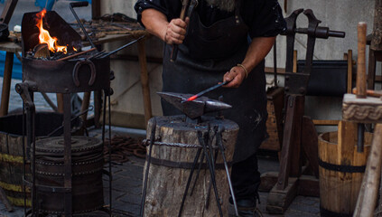 Herrero artesano trabajando sobre hierro caliente.