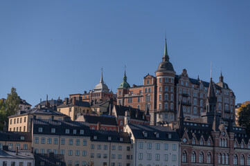 Fototapeta premium Old apartment’s houses at the street Bastugatan, tin roofs, dorms and chimneys in the district Södermalm a sunny autumn day in Stockholm