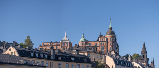 Fototapeta premium Old apartment’s houses at the street Bastugatan, tin roofs, dorms and chimneys in the district Södermalm a sunny autumn day in Stockholm