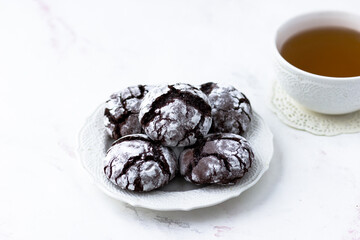 Cookies chocolate cracks on a white marble table. Biscuits and a cup of tea