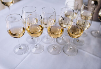 A lot, a row of glass glasses with champagne stands on a table in a bar, restaurant. Close-up photography, party.