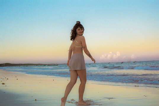 Woman running on the beach at sunset 