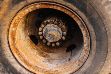 Rusty metal rim of a truck on a rubber tire close-up.
