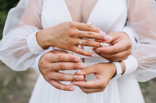 The bride and groom put gold rings on their fingers at the ceremony. Wedding photography, idea.