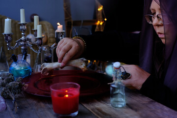 ed dish with water, candle lights in dark room of future fortuneteller, esoteric Oracle, session of black magic with bones of dead animals, divination for the future, activity at halloween party