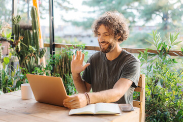 Man talking via video call on laptop  while sitting on the terrace 