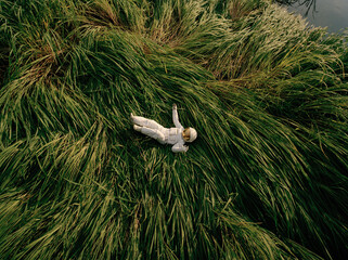 Astronaut lying on grass in nature