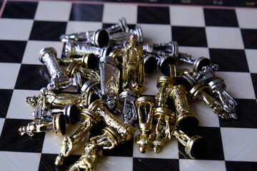 chess board with chess pieces. king standing, other pieces on the ground.