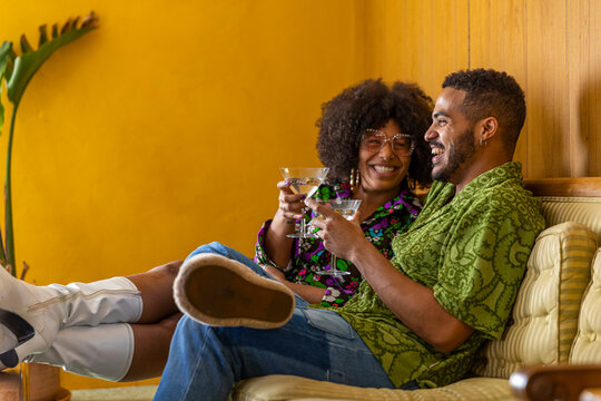 Black Couple laughing at party with cocktail