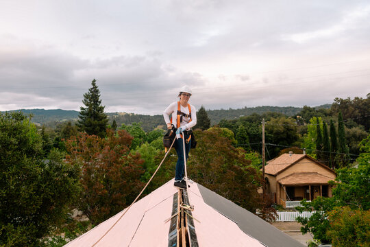 Woman working on roof with security harness
