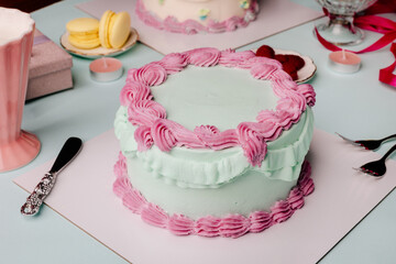 Blue and pink birthday cake with yummy treats and stylish tableware