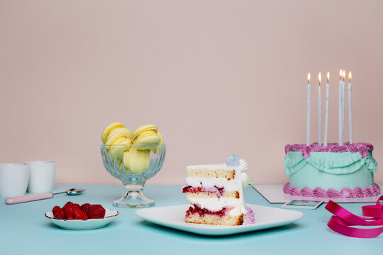 Birthday table set with colourful yummy desserts and vintage tableware