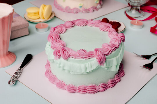Blue and pink birthday cake with yummy treats and stylish tableware