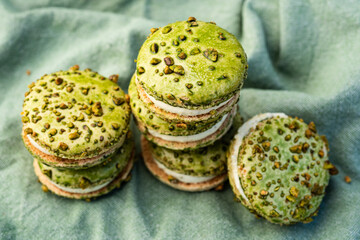 stacks of green color pistachio macaron cream filled sandwich cookies - 532537832
