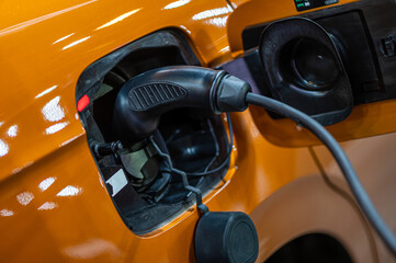 electric car connected to the charger, eco friendly technology, charging an electric car battery