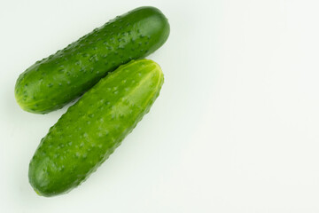 Two cucumbers are abundant on a white background. With a place for the inscription. Close-up.