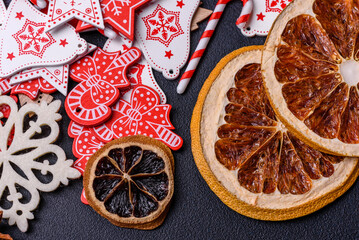 Christmas tree wooden toys in white and red colors, gingerbread and dried lemon and grapefruit slices