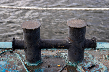 Knecht for mooring and fastening of mooring cables. Black farm laborer without a rope on an iron deck, side view. The bollard is a pair of cast-iron pedestals.