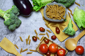 Zenith view. Healthy food, wholemeal macaroni pasta, vegetables and tomatoes, variety of food beneficial for health.