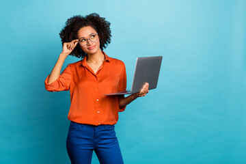 Portrait of beautiful trendy minded wavy-haired girl geek using laptop deciding copy space isolated on bright blue color background