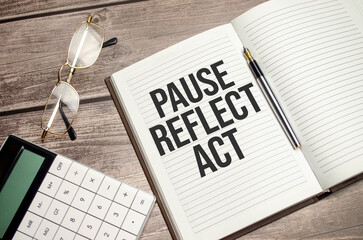 pause, reflect, act concept words on notepad and calculator and wooden background