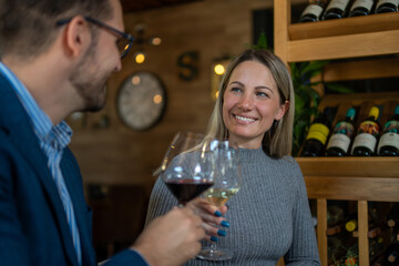 young, lovely couple making a toast for many more beautiful moments, with quality and rich white wine in the restaurant
