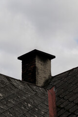 Old brick chimney on a background of the cloudy sky