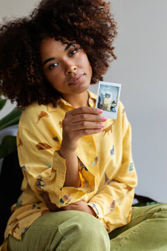 Latina afro-haired woman showing instant pic
