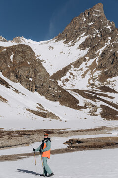 Faceless hiker standing near snowy mountains