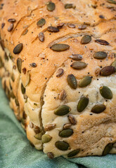 Close up detail of sliced white bread loaf seeded with pumpkin seeds, sunflower seeds, sesame seeds, poppy seeds - 532545658