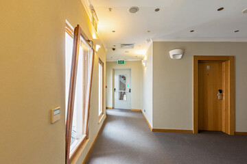 Fototapeta na wymiar Corridor with wooden doors in a hotel interior