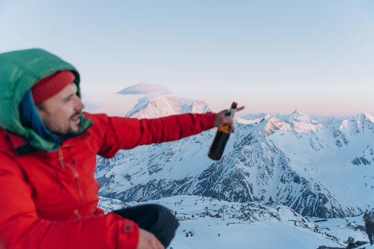 Young male camper pointing away in snowy mountains