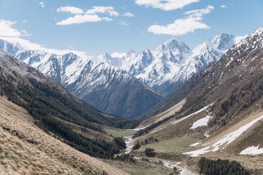 Snowy mountains and valley on cloudy day