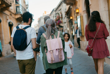Group of people walking on sunny old town street in European city