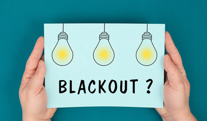 The word blackout is standing under lightbulbs, power cut out, uncertain energy supply
