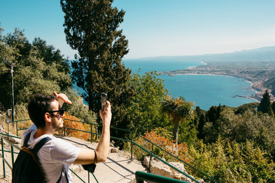 Tourist taking picture of panoramic view of Mediterranean Sea