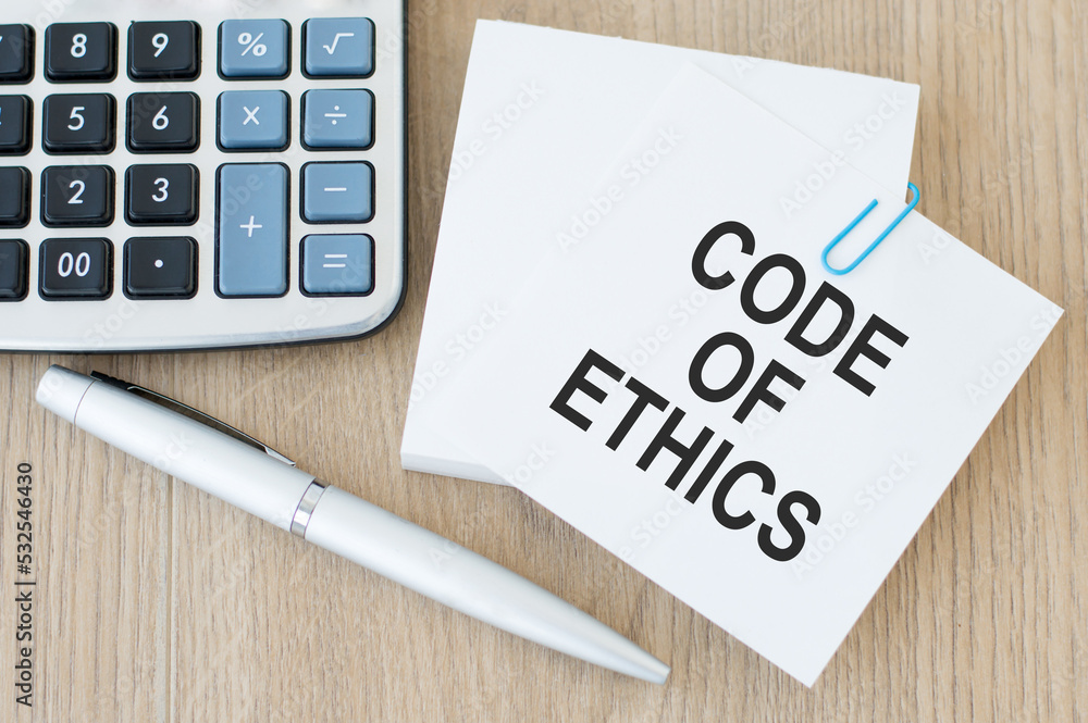 Poster code of ethics text on the card on the paper clip to the sheets for notes on a wooden background nex